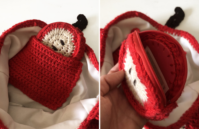 Inside view of a crocheted apple slice bag featuring a red crocheted pocket with a small apple-shaped wallet tucked inside.