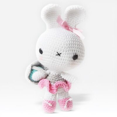 Crochet Easter bunny carrying a basket with an egg in it.