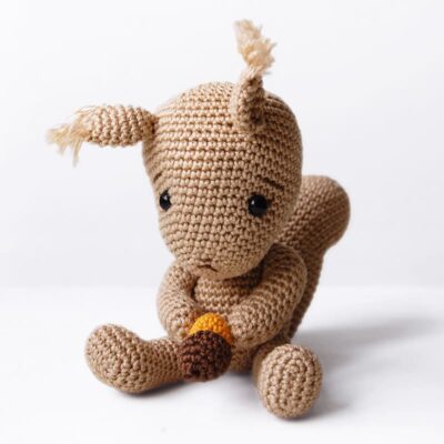 Cute crochet squirrel holding an acorn.