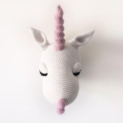 Crochet unicorn head mounted on the wall