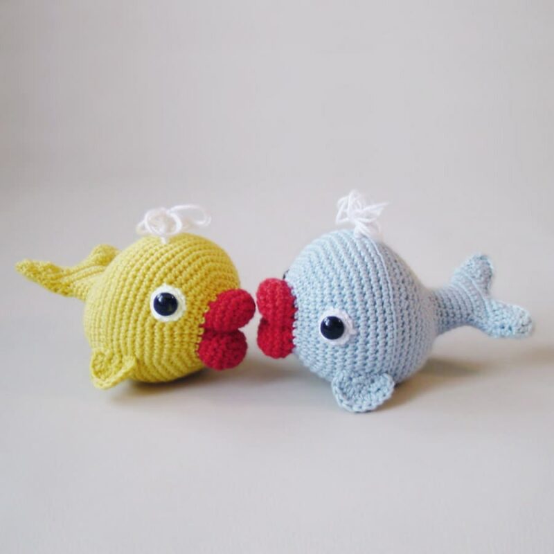 Two crochet whales, a blue and a yellow one.