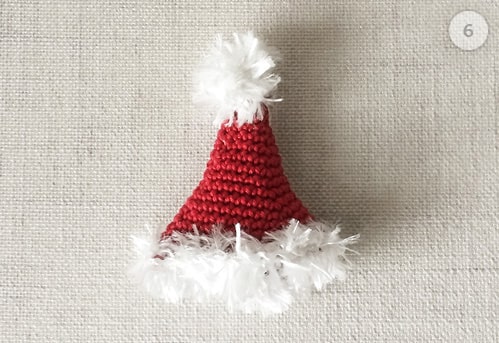 Santa's hat is crocheted and set aside.